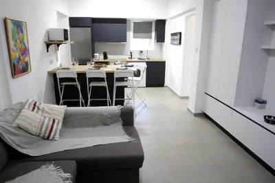 a living room with a couch and a kitchen at Haris' Apartment Larnaca in Larnaka