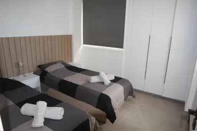 two beds in a room with crosses on them at Haris' Apartment Larnaca in Larnaka