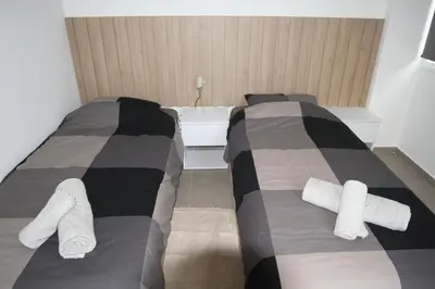 two beds in a room with towels on them at Haris' Apartment Larnaca in Larnaka
