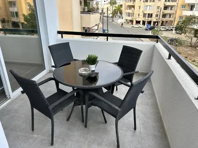 a table and four chairs on a balcony with a view at Haris' Apartment Larnaca in Larnaka