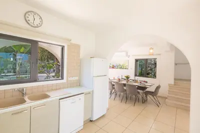 a kitchen and dining room with a table and a clock at Mylos Villas in Protaras