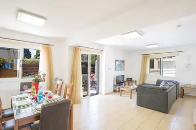 a living room with a table and a dining room at Mylos Villas in Protaras