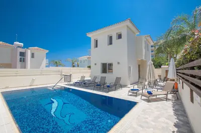 a swimming pool in front of a villa at Mylos Villas in Protaras