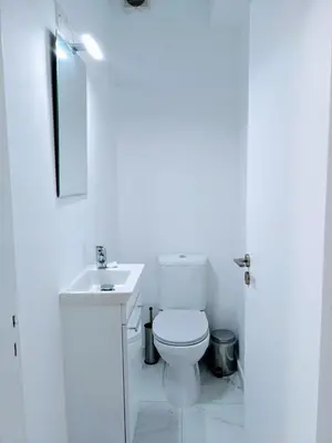 a white bathroom with a toilet and a sink at Diana Apartment in Limassol