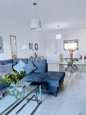 a living room with a blue couch and a table at Diana Apartment in Limassol
