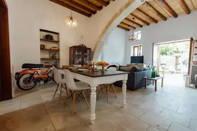 a dining room and living room with a table and a motorcycle at The Yard Traditional Residence in Vasa Kilaniou