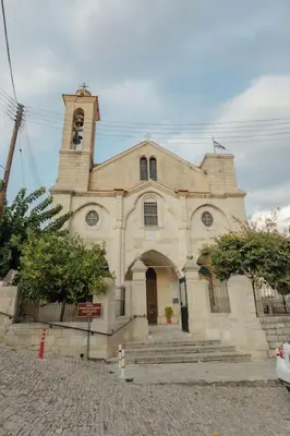 a large church with a clock tower on top at The Yard Traditional Residence in Vasa Kilaniou