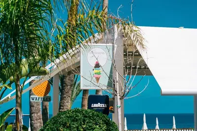 a sign in front of a beach with palm trees at SunnyVillas 1 Bedroom Swimming Pool COR in Protaras