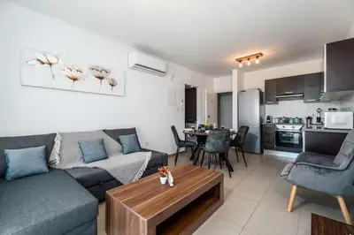 a living room with a couch and a table at SunnyVillas 1 Bedroom Swimming Pool COR in Protaras