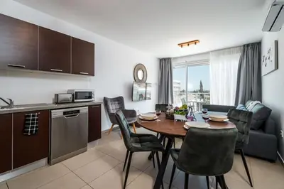 a kitchen and living room with a table and chairs at SunnyVillas 1 Bedroom Swimming Pool COR in Protaras