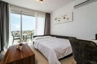 a bedroom with a bed and a table and a window at SunnyVillas 1 Bedroom Swimming Pool COR in Protaras