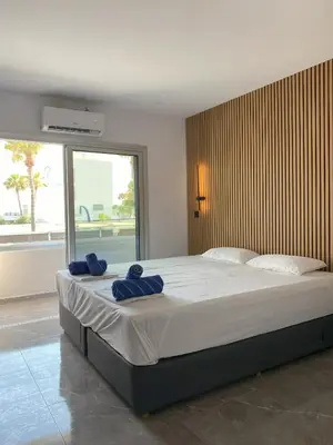 a bedroom with a large bed with blue towels on it at Nissi Avenue Studios in Ayia Napa