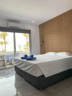 a bedroom with a bed with blue towels on it at Nissi Avenue Studios in Ayia Napa