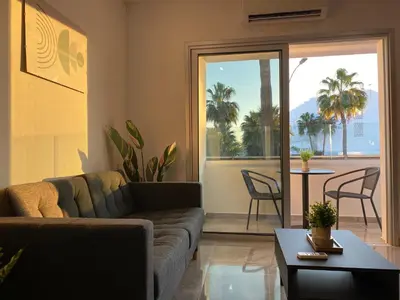 a living room with a couch and a table at Nissi Avenue Studios in Ayia Napa