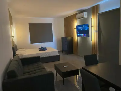 a hotel room with a bed and a flat screen tv at Nissi Avenue Studios in Ayia Napa