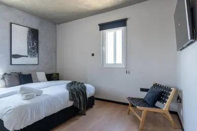 a bedroom with a bed and a chair and a window at The Penthouse - 3BR Seaview with Private Pool in Larnaca in Larnaka
