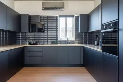a large kitchen with black cabinets and a window at The Penthouse - 3BR Seaview with Private Pool in Larnaca in Larnaka