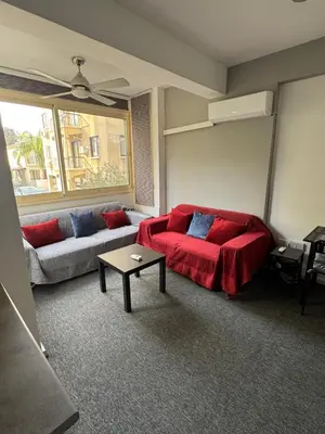 a living room with a red bed and a couch at Georges 2 Bedroom Apartment in Limassol