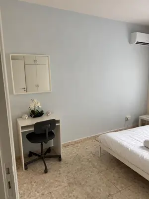 a bedroom with a desk with a bed and a chair at Georges 2 Bedroom Apartment in Limassol