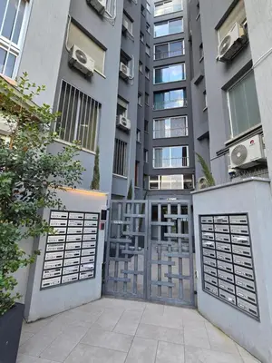 a building with two garage gates in front of it at 1 room apartment on the 1st line in Limassol