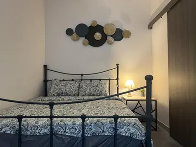a bedroom with a bed and a clock on the wall at 1 room apartment on the 1st line in Limassol