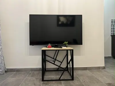 a flat screen tv on a wall with a table at 1 room apartment on the 1st line in Limassol