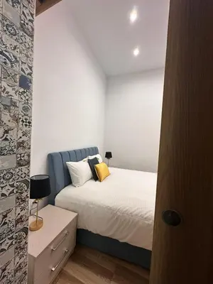 a bedroom with a bed with a blue headboard at Joanna's Rooms in Kalopanayiotis