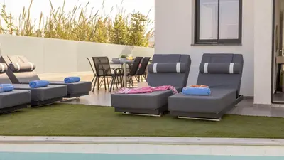 a group of chairs on a patio with a table at Villa Iva by the Sea in Paralimni