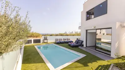 a swimming pool in the backyard of a house at Villa Iva by the Sea in Paralimni