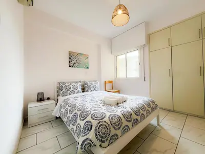 a white bedroom with a bed and a window at Samos City Center, 2BR Sleeps 4 in Limassol
