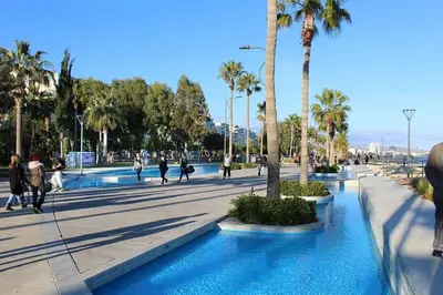 a group of people walking in a street with palm trees at Samos City Center, 2BR Sleeps 4 in Limassol