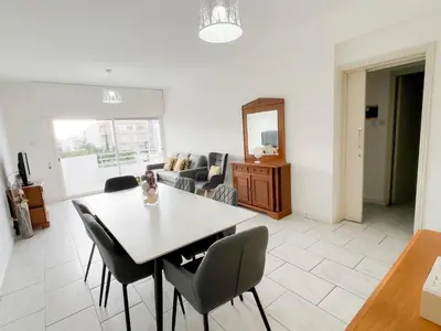a living room with a table and chairs at Samos City Center, 2BR Sleeps 4 in Limassol