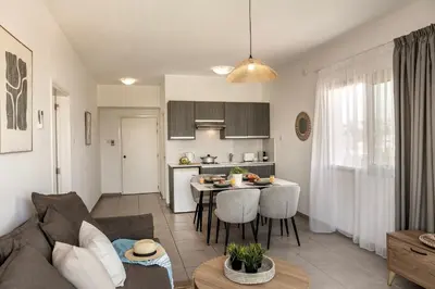 a living room and kitchen with a couch and a table at Somantonia apartments in Protaras