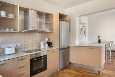 a kitchen with wooden cabinets and a stainless steel refrigerator at Phaedrus Living Evergreen Nicosia City Residence in Nicosia