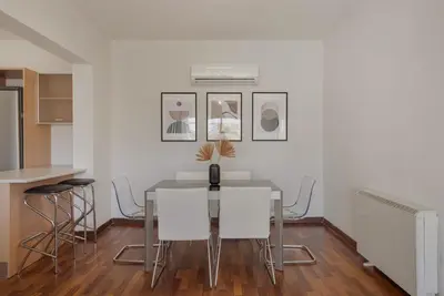 a dining room with a glass table and white chairs at Phaedrus Living Evergreen Nicosia City Residence in Nicosia