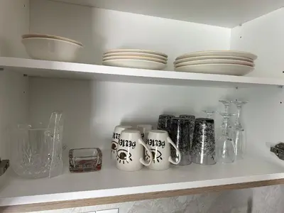 a kitchen shelf with cups and plates on it at -Mari- Cozy Stay at Engomi Near UNIC in Nicosia