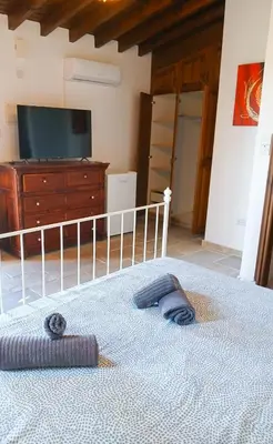 a bedroom with a bed with a dresser and a tv at Skarinou Panorama Room in Skarinou
