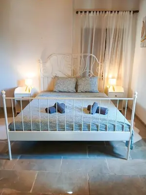 a bedroom with a white bed with two lamps at Skarinou Panorama Room in Skarinou