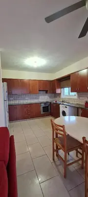 a kitchen with a table and a table and chairs at Parlena Latsia in Laxia