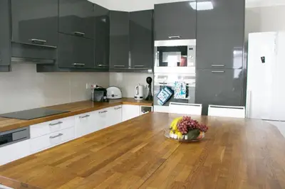 a kitchen with a wooden table with a bowl of flowers on it at Freshness Modern 2 Bedroom Apartment with Balcony & Stunning Sea View in Central Limassol in Limassol