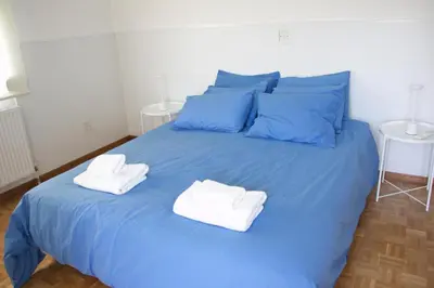 a blue bed with two towels on top of it at Freshness Modern 2 Bedroom Apartment with Balcony & Stunning Sea View in Central Limassol in Limassol
