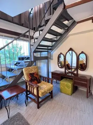 a room with a chair and a staircase with mirrors at Finikous Cottage House-Agros in Agros