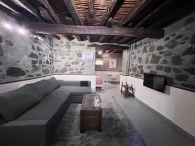a living room with a couch and a tv at Finikous Cottage House-Agros in Agros