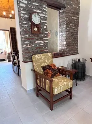 a room with a chair and a clock on a wall at Finikous Cottage House-Agros in Agros