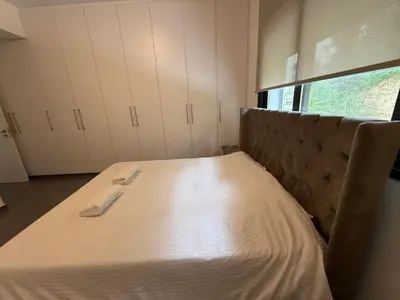 a bed in a room with white sheets on it at Glabur Stays - Nicosia Elite 2BDR in Nicosia