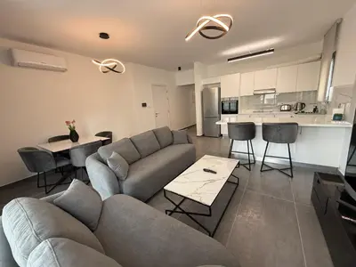 a living room with a couch and tables and a kitchen at Glabur Stays - Nicosia Elite 2BDR in Nicosia