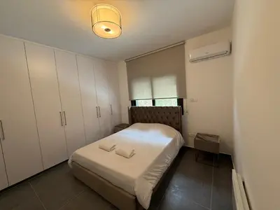 a small bedroom with a bed and white cabinets at Glabur Stays - Nicosia Elite 2BDR in Nicosia
