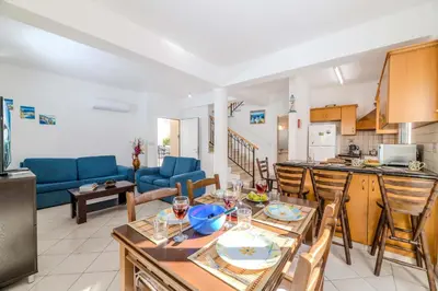 a kitchen and living room with a table and chairs at Villa Kos #7 in Paralimni