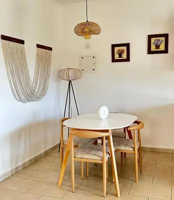 a table and chairs in a room with a lamp at Bohemian Oasis in Episkopi Lemesou