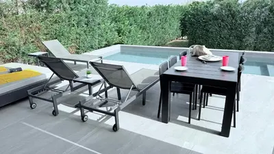 a patio with a table and chairs next to a swimming pool at TooCoool Villa - Azure Seaview in Protaras
